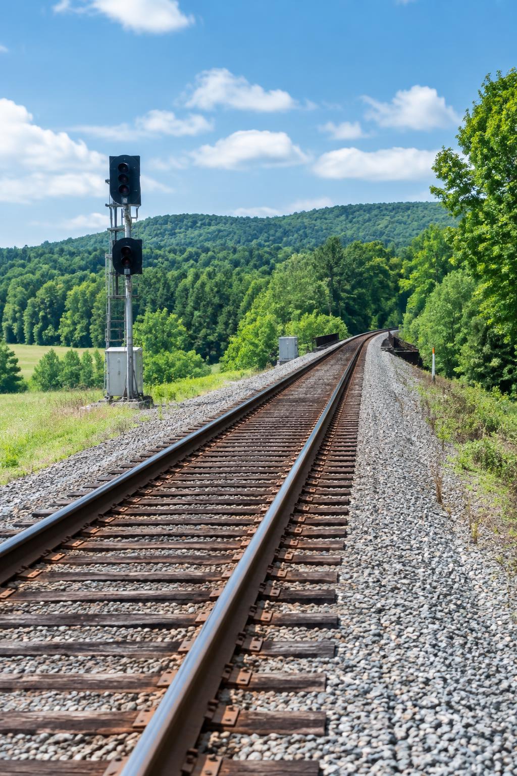 Railroad tracks through green countryside